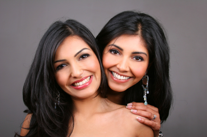 2 Smiling, Females of South Asian Descent displaying white teeth